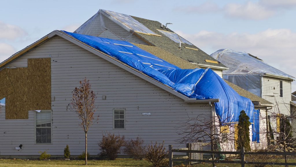 roof of home covered with tarp after large storm