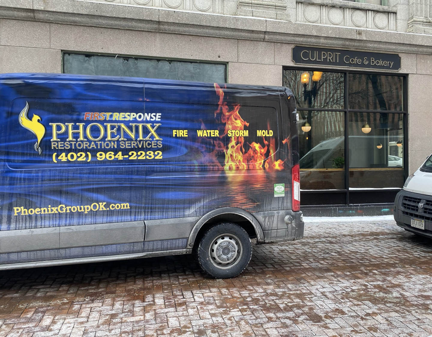 Phoenix Restoration truck parked outside businesses downtown